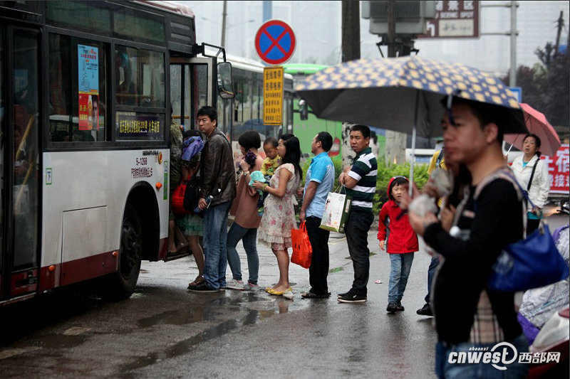 5月17日早高峰，市民一边排队，一边张望后面有没有人少的车可以坐。 